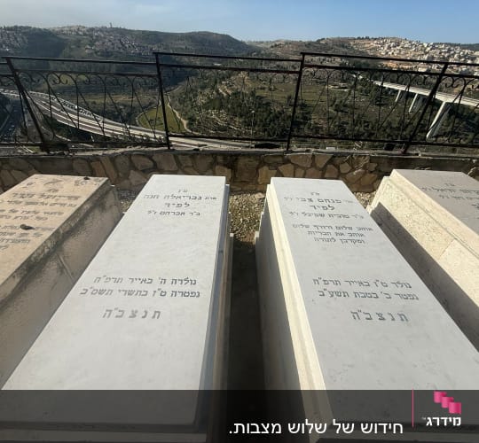 מצבות עם כיתוב בעברית על רקע נוף הררי